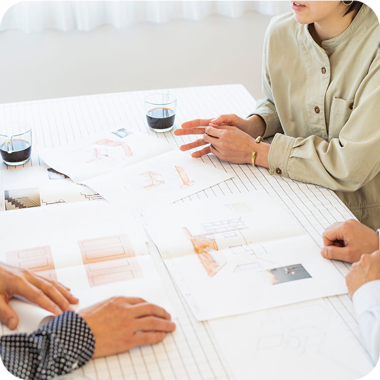設計図を囲んで打ち合わせをする様子